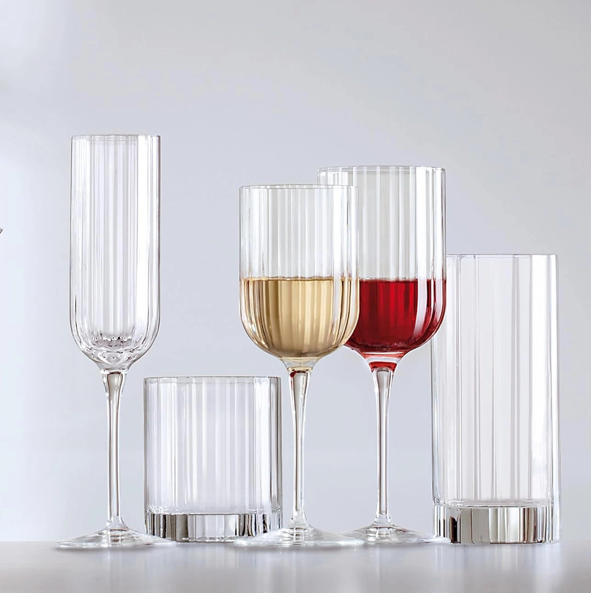 Juego de copas y vasos Bach de Luigi Bormioli, mostrando el diseño tallado y la base sólida.