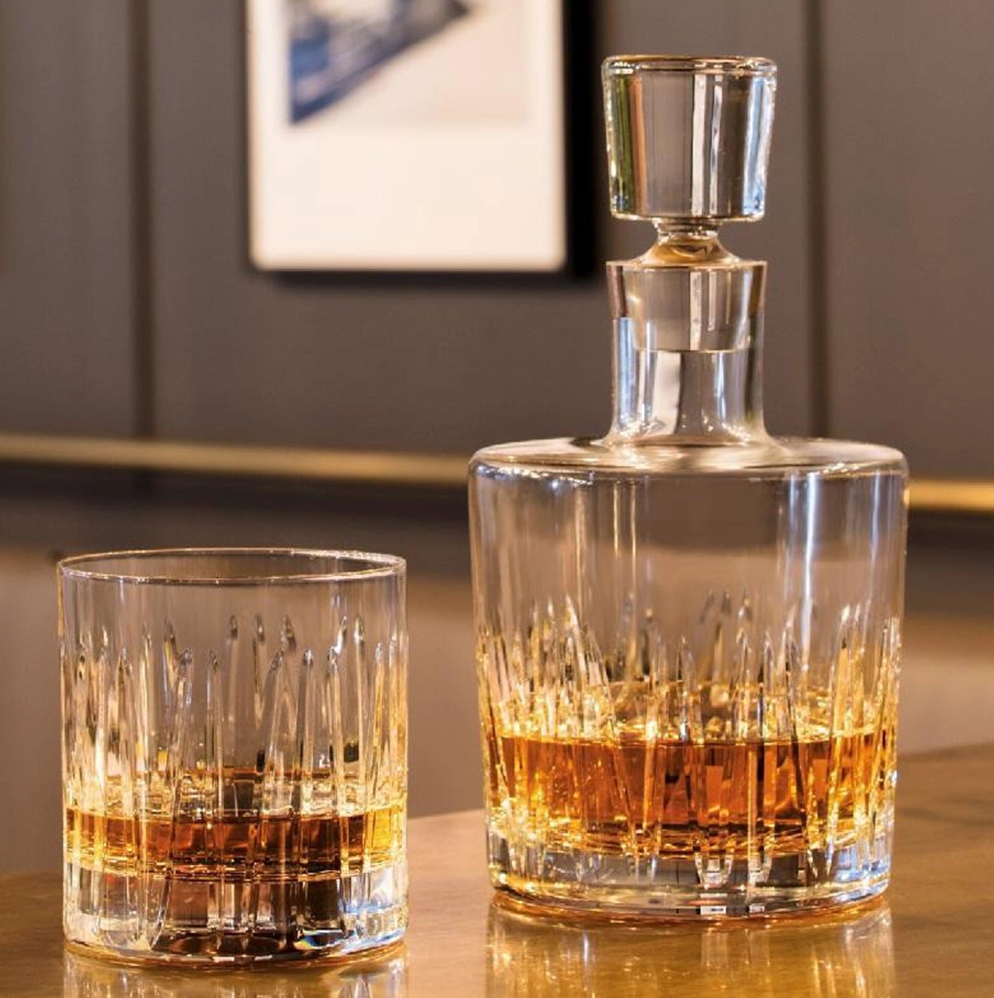 Dos piezas de la colección Basic Bar Classic, una licorera de lujo y un vaso de whisky, mostrando la funcionalidad de la línea.