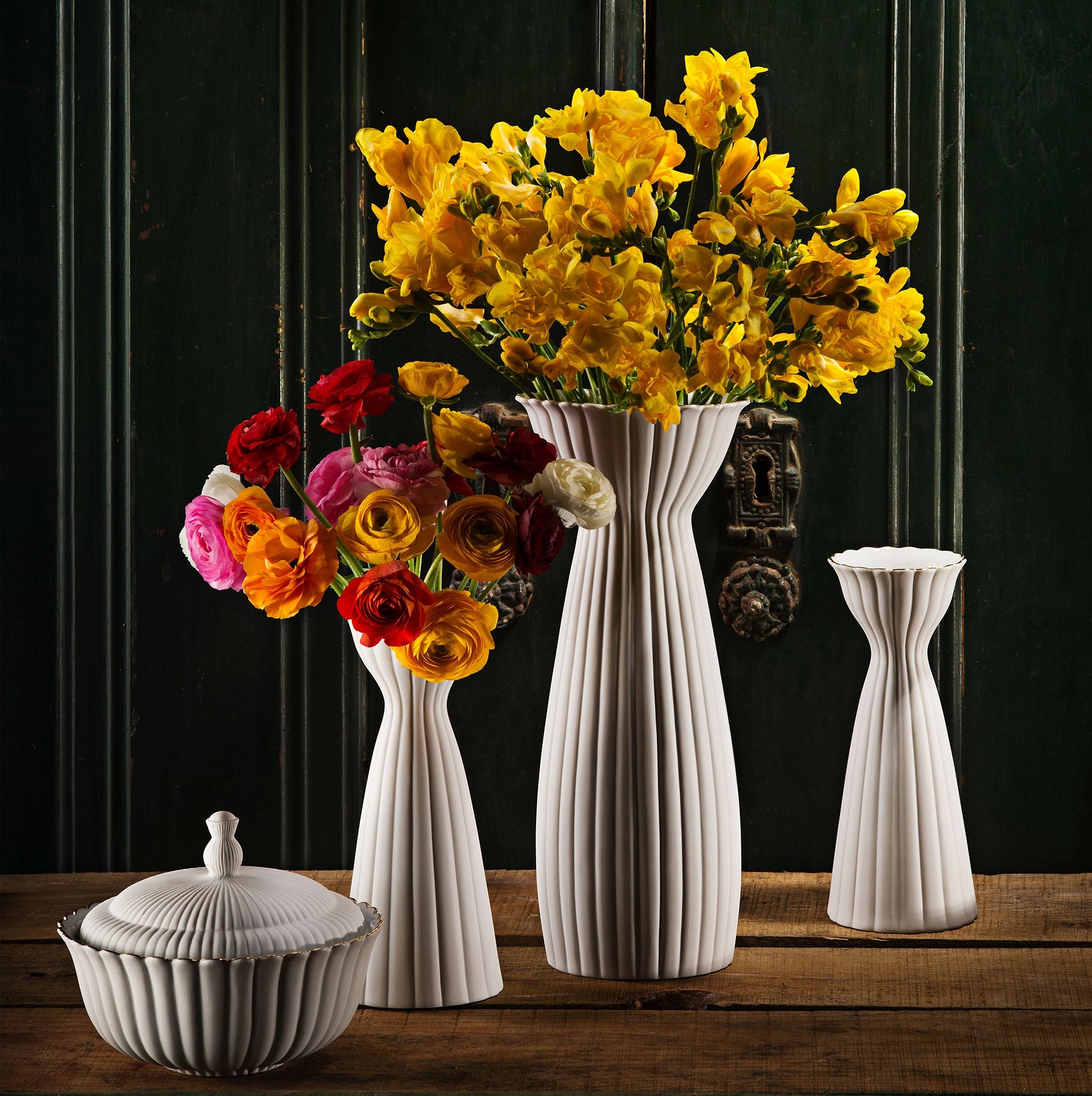 Floreros con flores frescas, destacando el acabado y la forma de cada pieza.