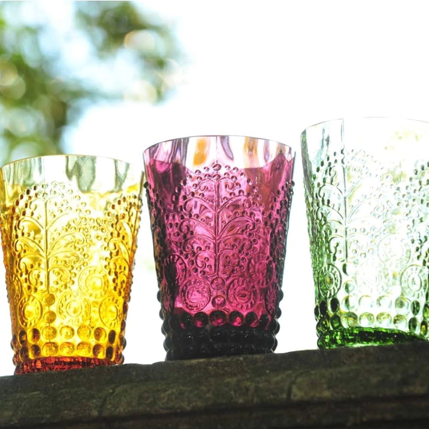 Set de vasos bajos Tree de Casa Alegre en colores variados (ámbar, verde, morado) sobre una mesa de madera.