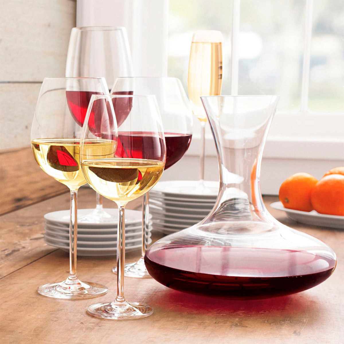 Conjunto de copas de vino & decantador de la colección Diva de Zwiesel, con reflejos de luz en su cristal.