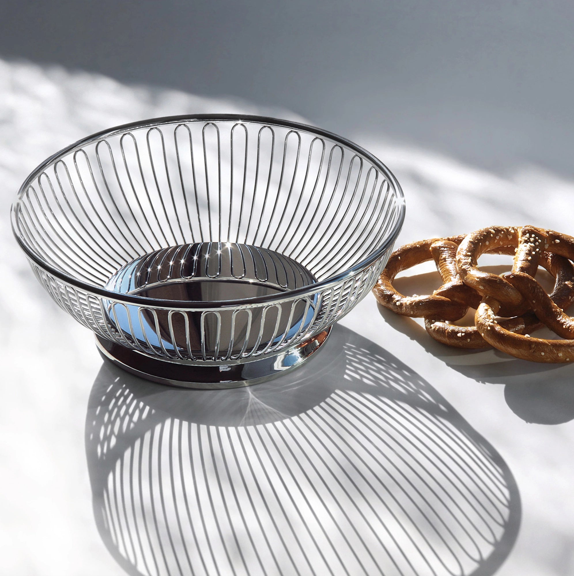 Panera de acero inoxidable con un borde de lino, con pan artesanal en su exterior.