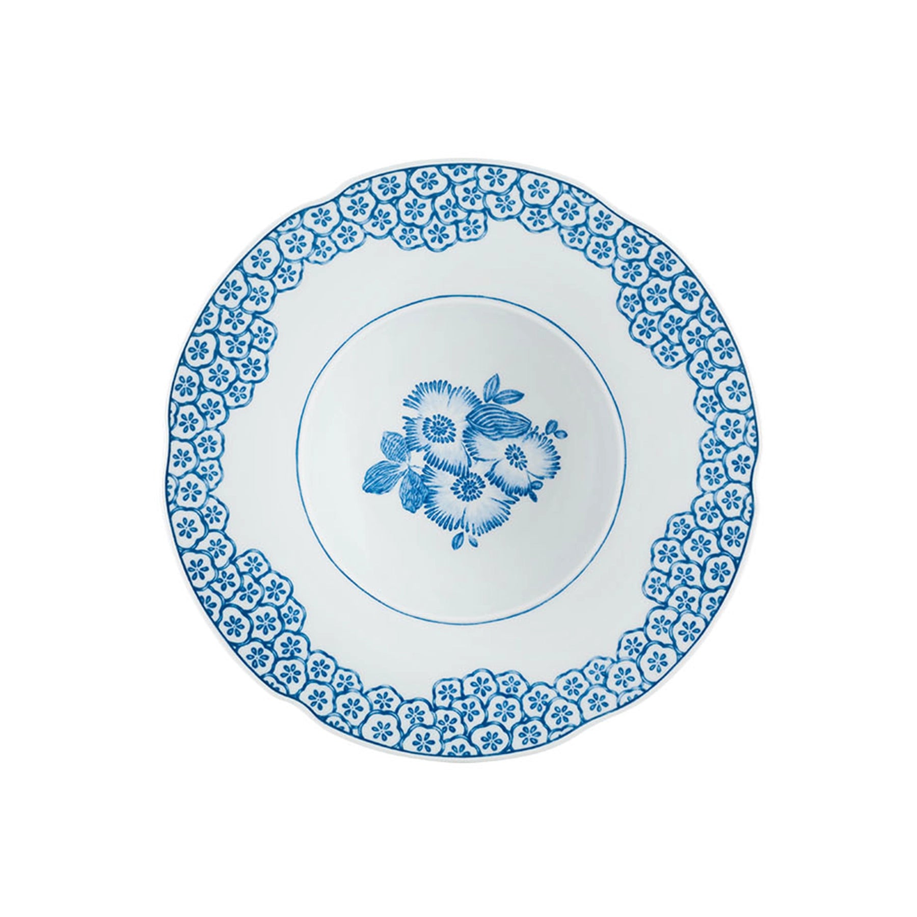 Detalle del patrón botánico interior y el fino fileteado pintado a mano en el contorno del plato hondo Coralina Azul.