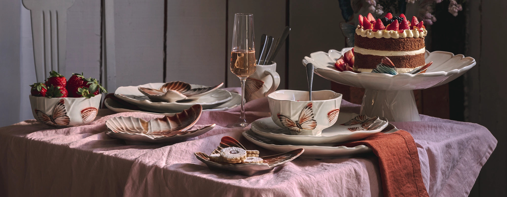 Vajilla completa de la colección Cloudy Butterflies de Bordallo Pinheiro sobre una mesa, lista para servir.