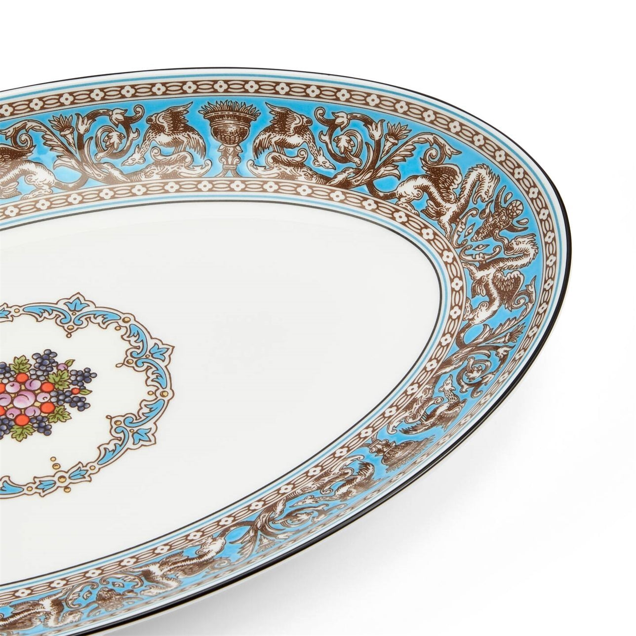 Detalle del borde de la bandeja ovalada Florentine Turquoise, mostrando motivos místicos.