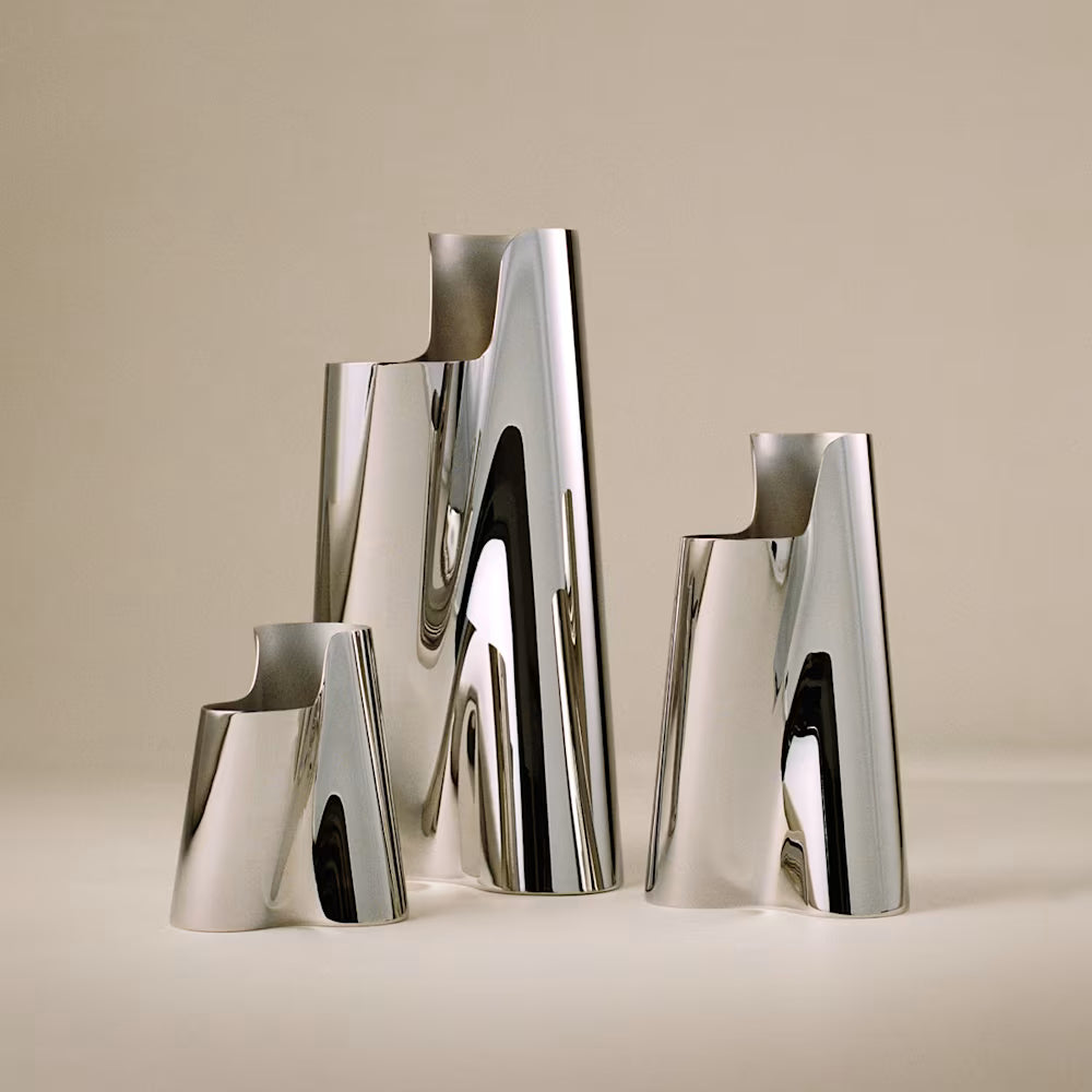Primer plano del florero Lituus, resaltando el brillo del acero inoxidable pulido a espejo y las líneas limpias.