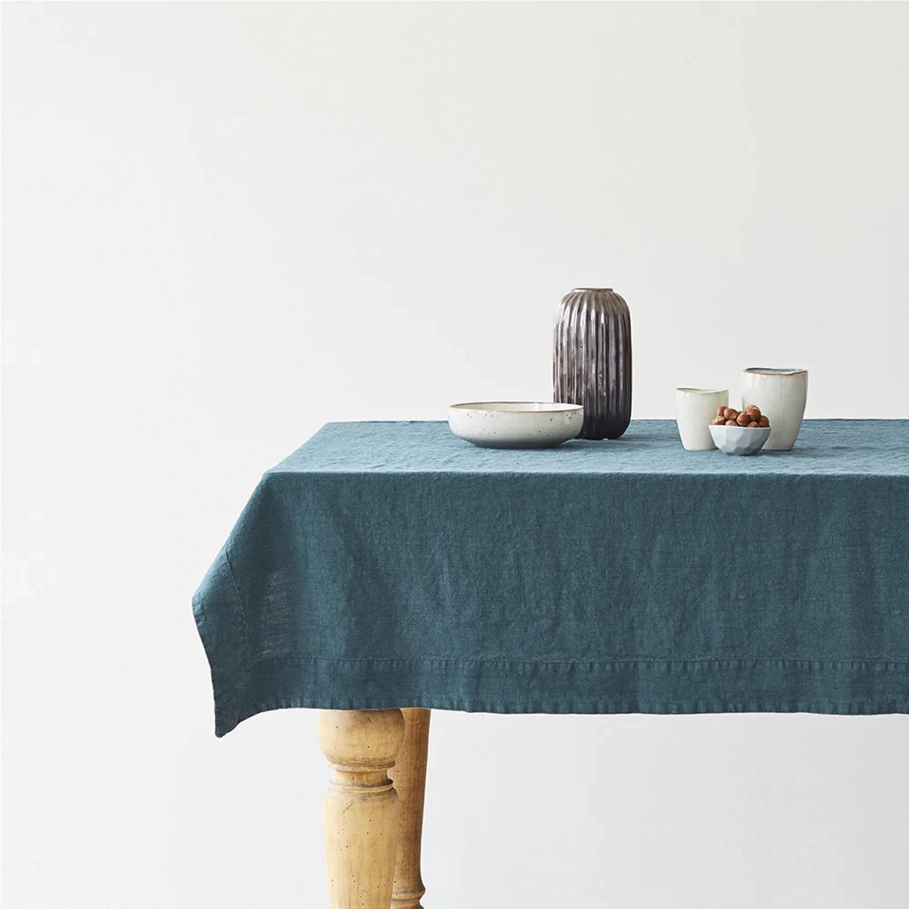Mantel Deep Water sobre una mesa con vajilla neutra y decoración floral