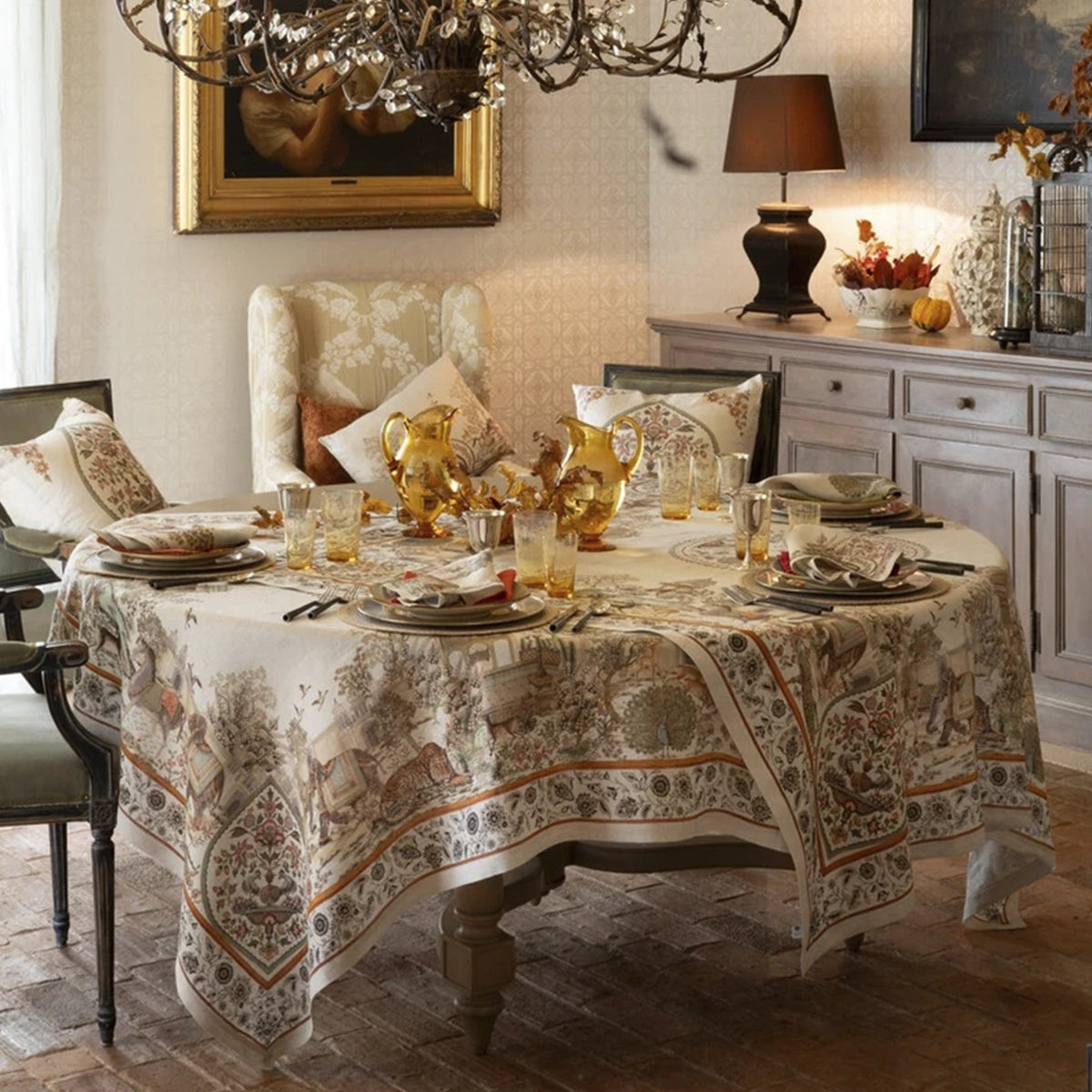 Mantel de lino Mudra de Tessitura Toscana Telerie vistiendo una mesa formal de comedor con vajilla de lujo, copas de cristal y cubertería elegante.