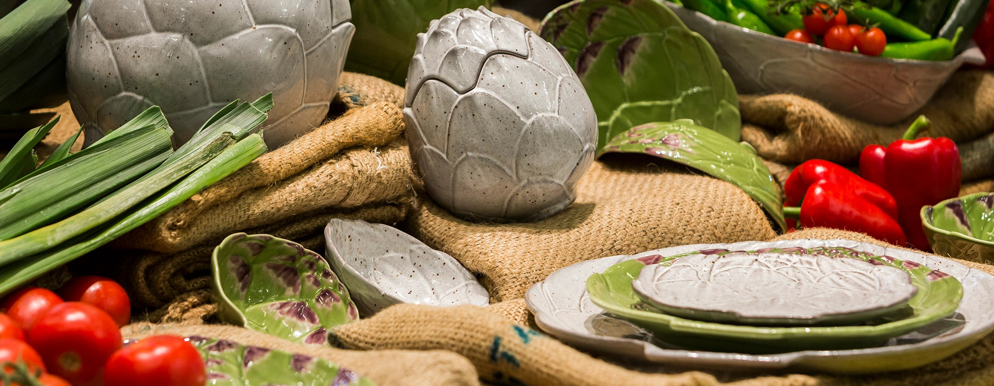 Composición de mesa con la vajilla Alcachofa de Bordallo Pinheiro, mostrando su elegancia naturalista.