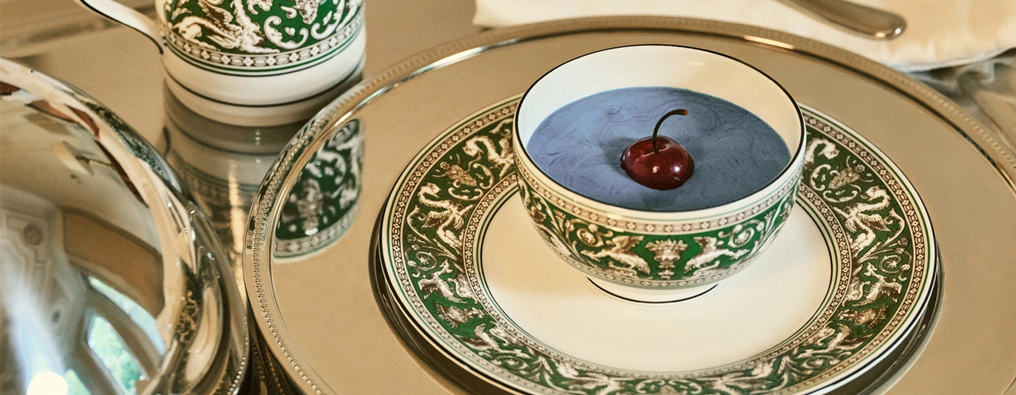 Primer plano de un plato de la vajilla Florentine Verde de Wedgwood, mostrando los detalles intrincados del diseño con relieve.