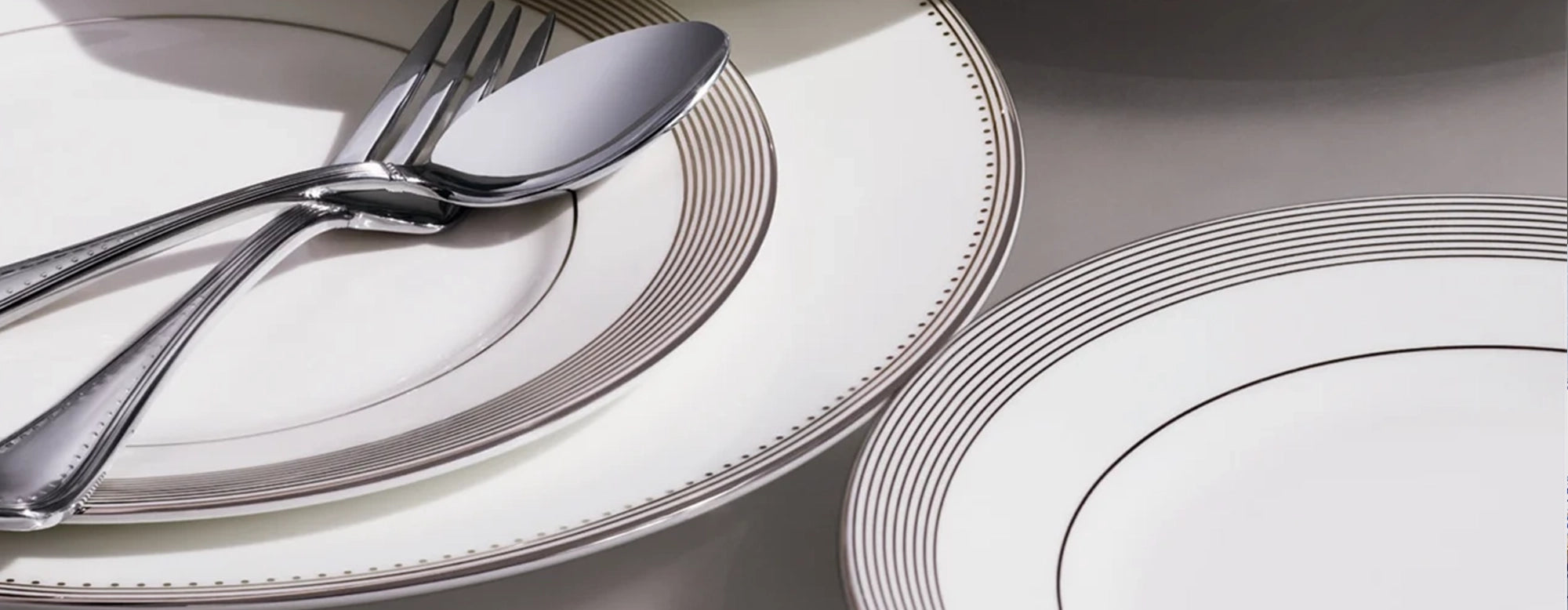 Platos de porcelana de la colección Grosgrain de Wedgwood con el sutil patrón acanalado en el borde.