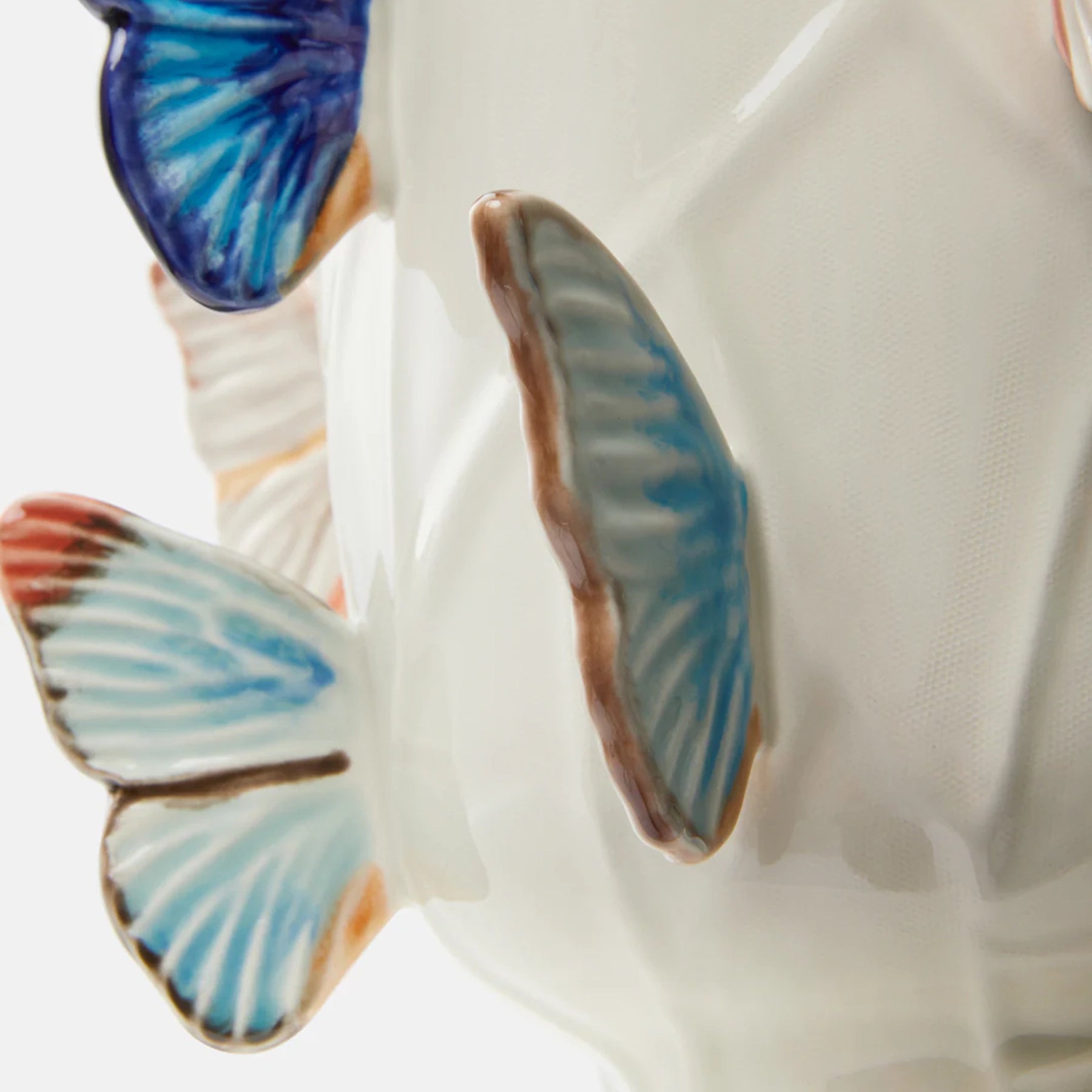Detalle de mariposas tridimensionales sobre porcelana blanca