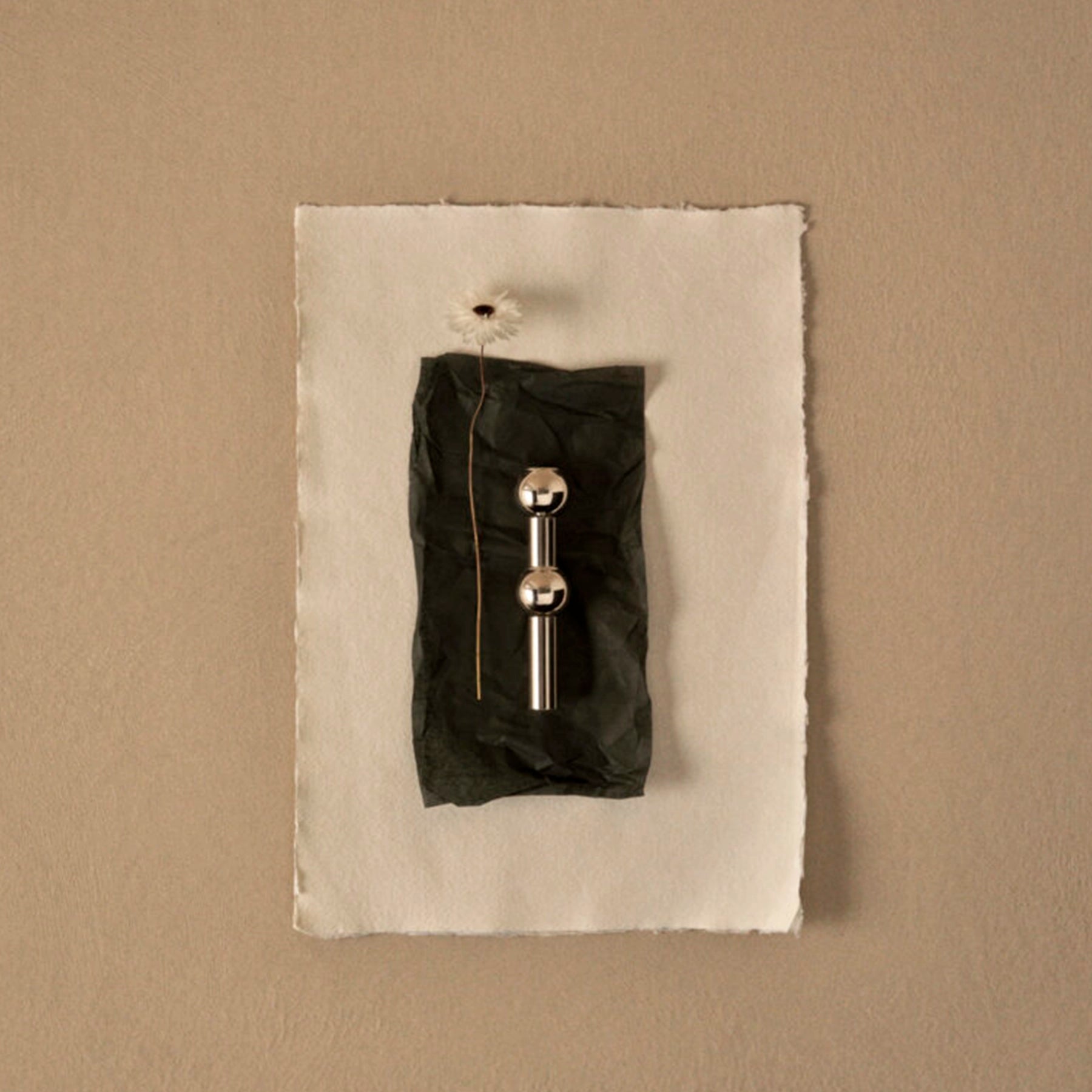 Florero STOFF Nagel, resaltando el reflejo del acabado en cromo y la calidad del metal.