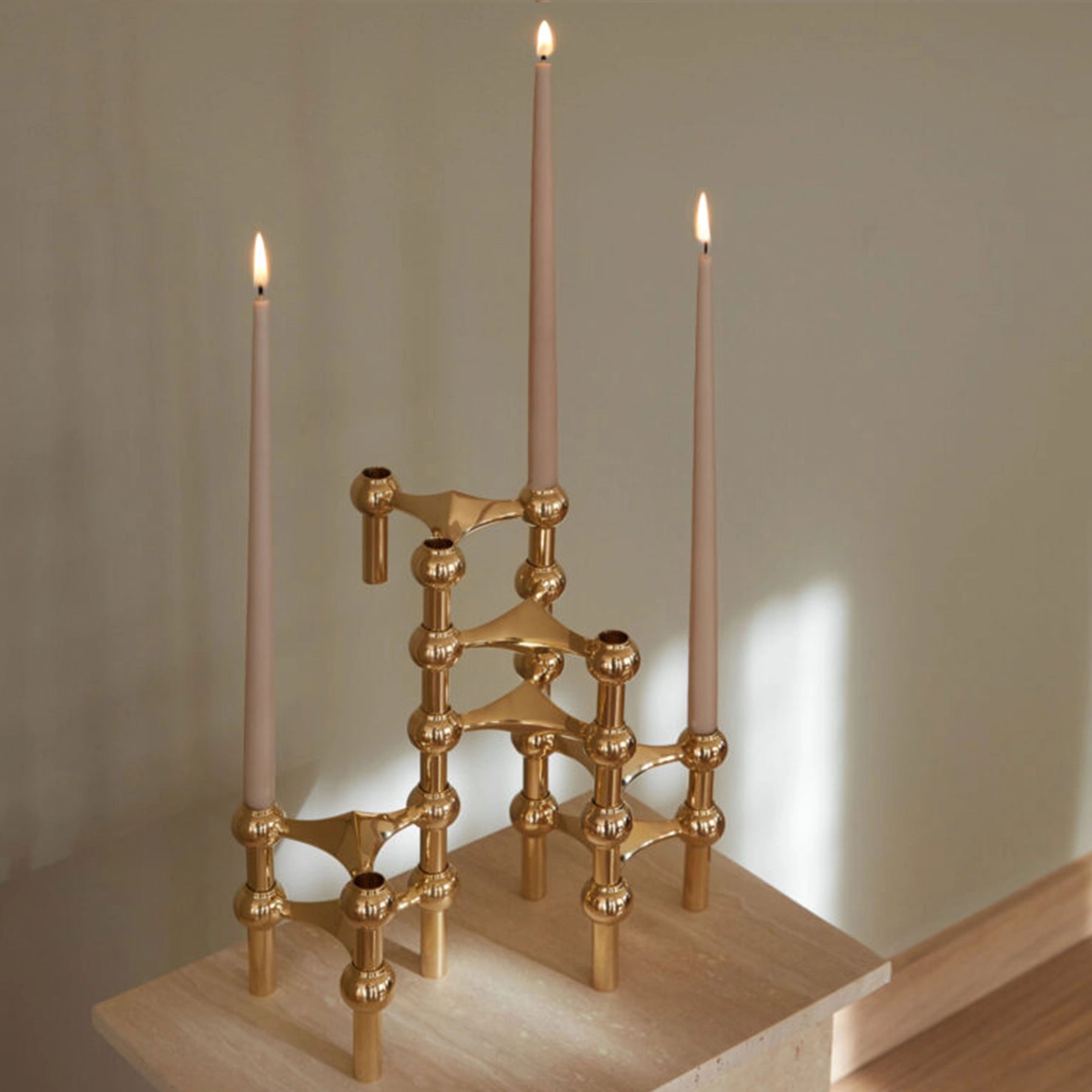 Candelabro dorado STOFF Nagel exhibido como pieza central en una mesa.