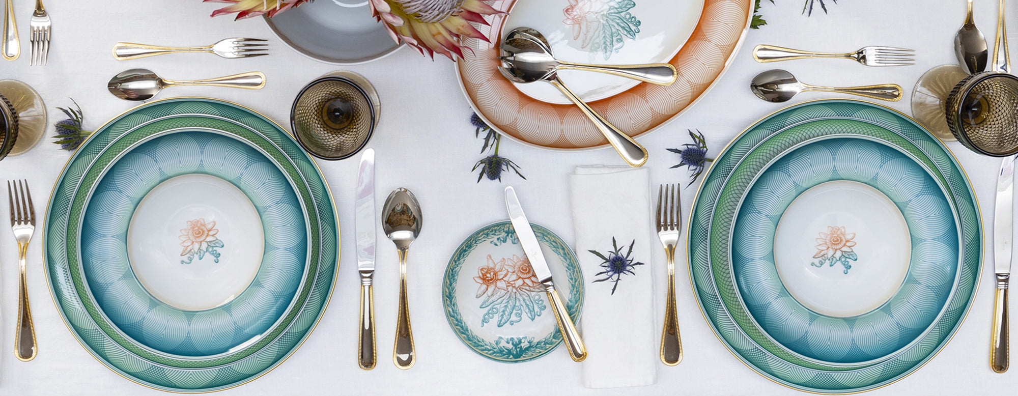 Mesa decorada con la vajilla de porcelana Treasures de Vista Alegre inspirada en grabados de sellos y billetes.