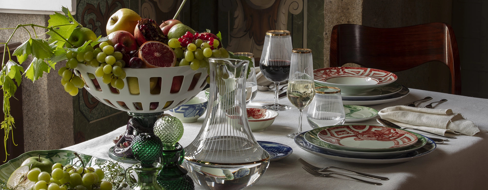 Composición de mesa con la vajilla The Meaning de Vista Alegre en tonos multicolor con patrones naturalistas.