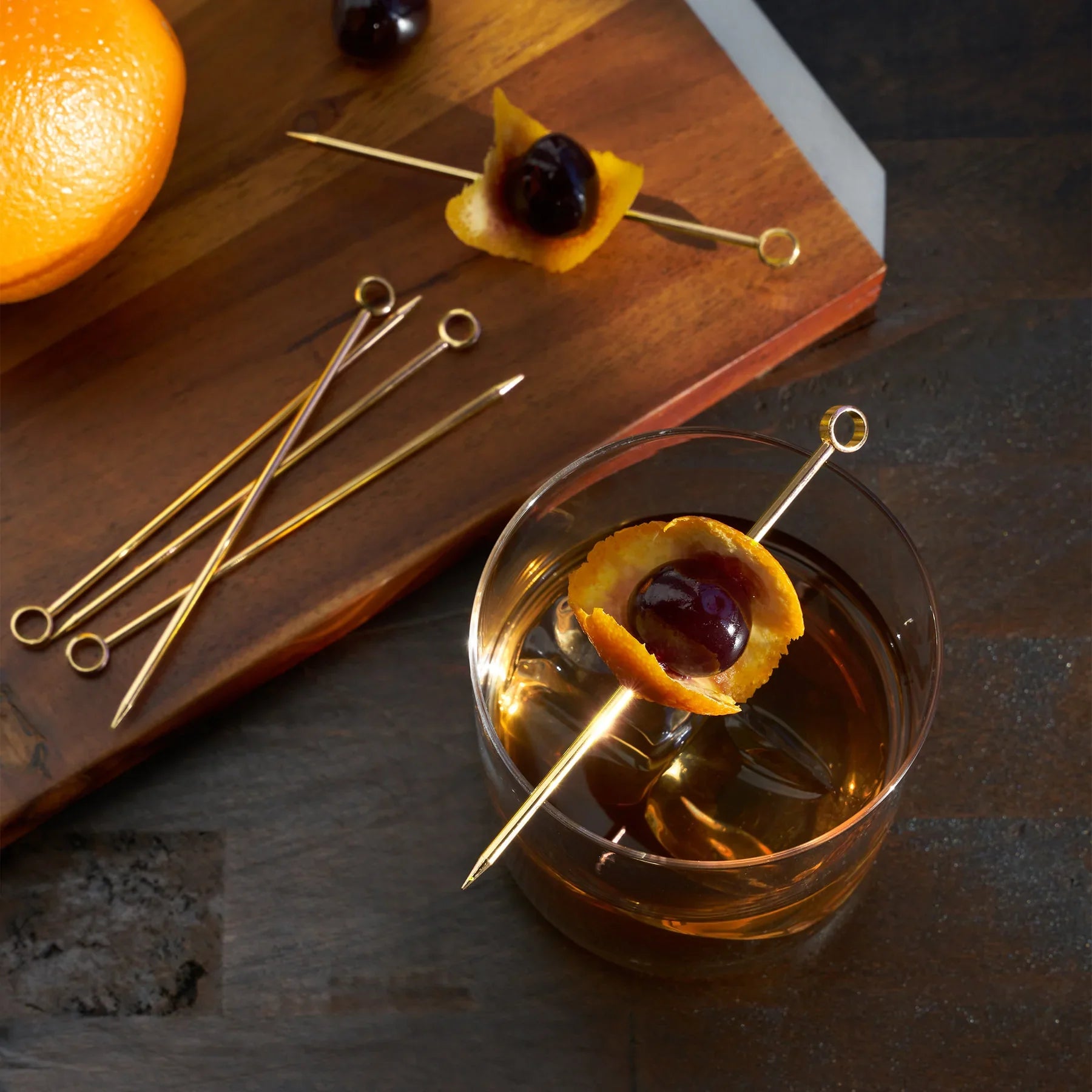 Juego de palillos de acero inoxidable para aceitunas y brochetas en un soporte.