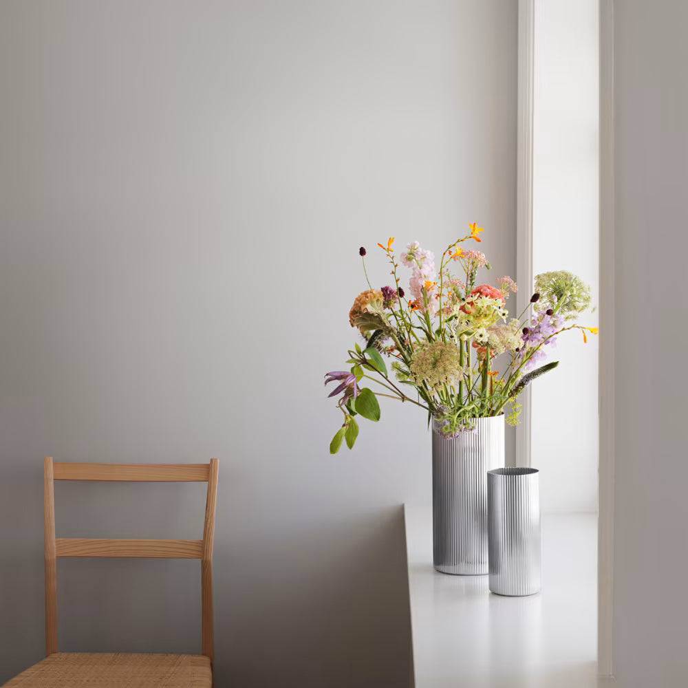Florero grande Bernadotte de Georg Jensen, mostrando el diseño estriado y pulido con un gran ramo de flores.
