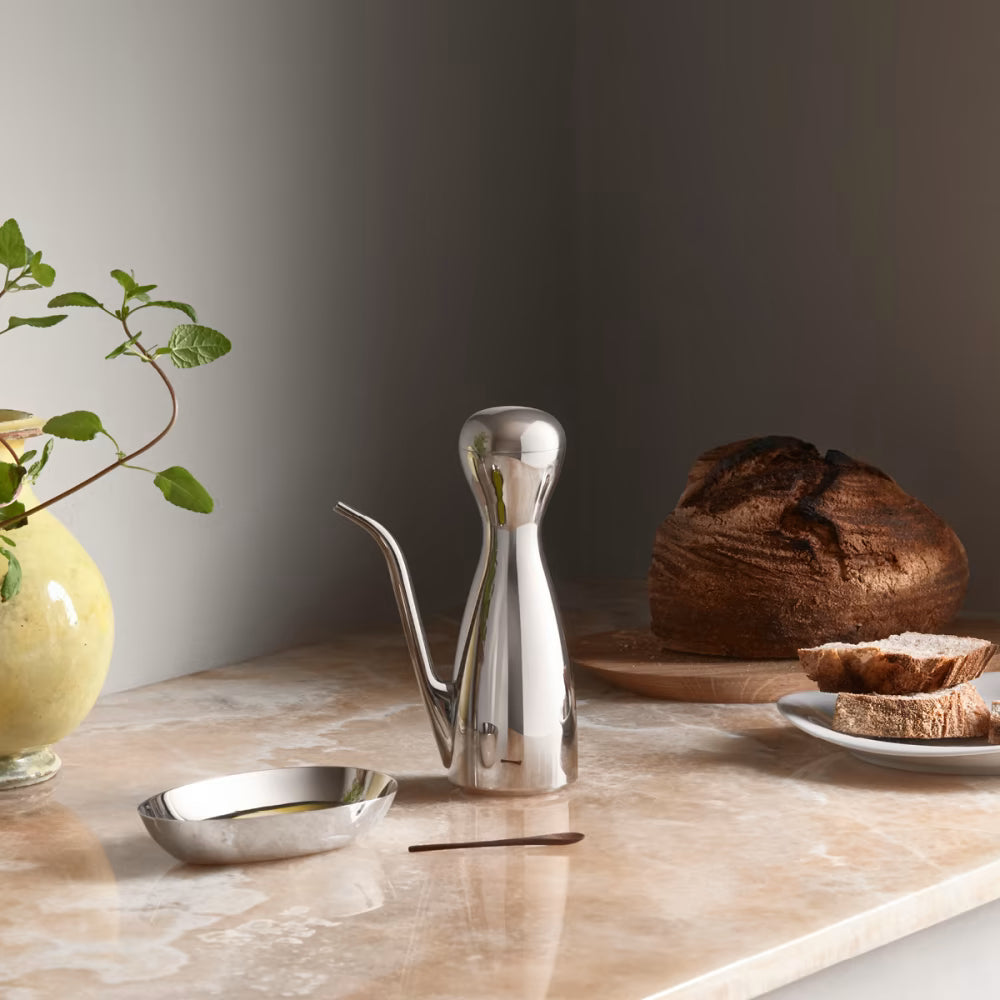 Fotografía de estilo de vida de la aceitera Alfredo, usada en una mesa de comedor con otros condimentos.