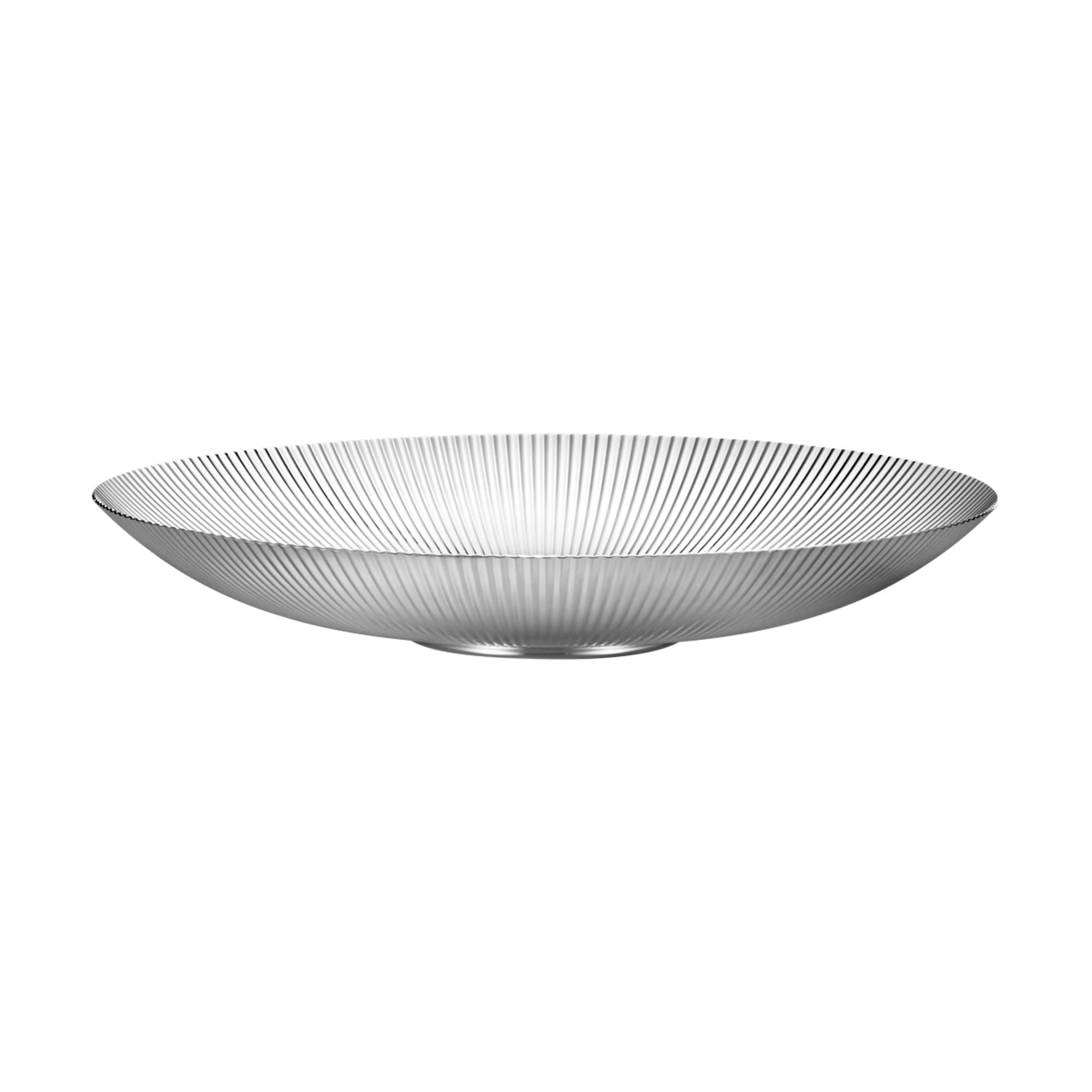 Primer plano del centro de mesa Bernadotte, resaltando el brillo del acero inoxidable pulido a espejo y las estrías.