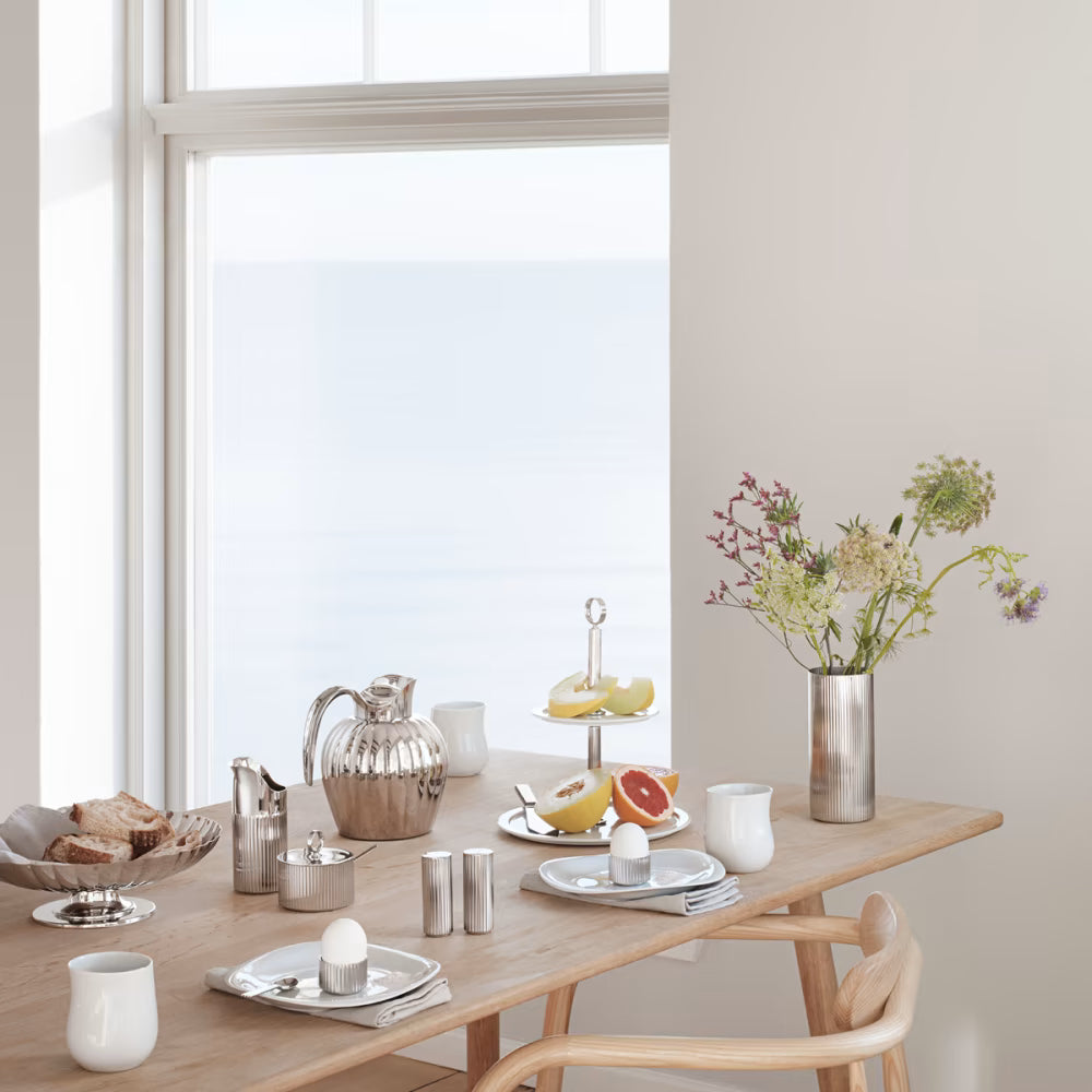 Fotografía de estilo de vida del florero grande Bernadotte, decorando una mesa de comedor elegantemente puesta.