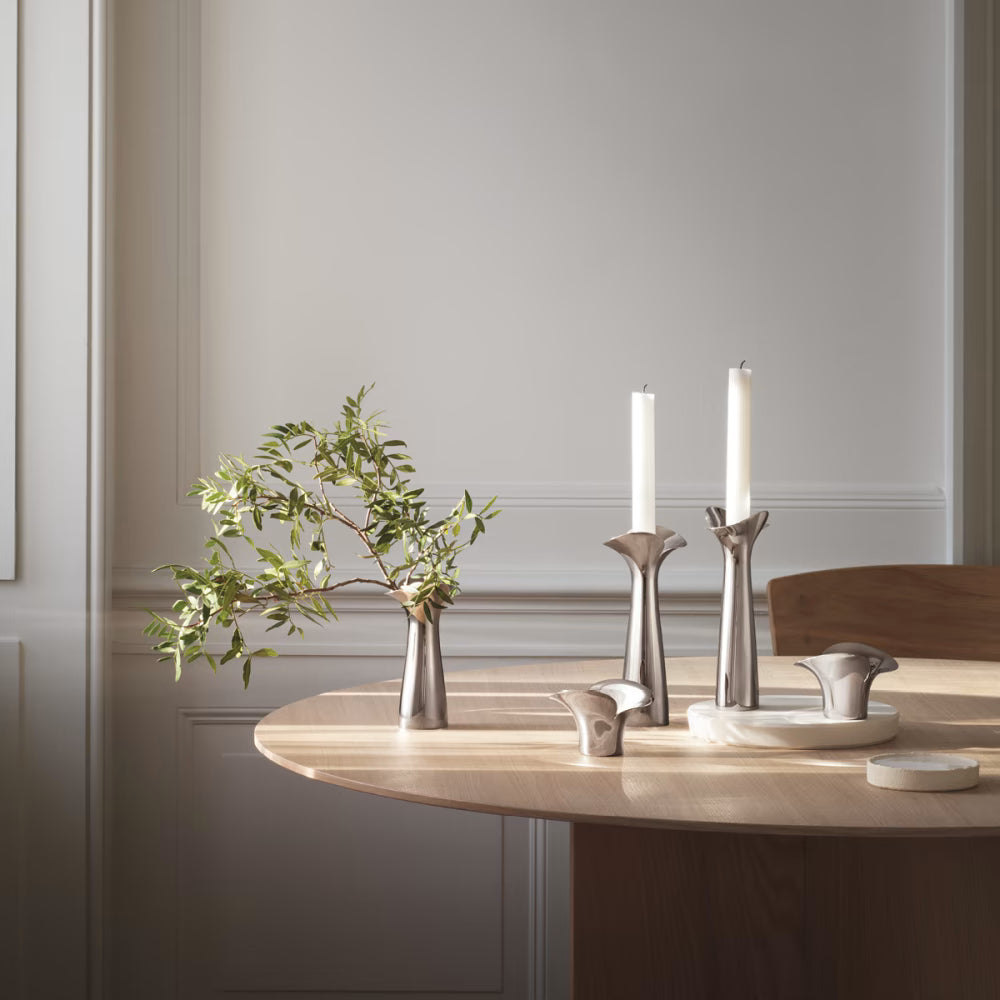 Fotografía de estilo de vida del set de candelabros Botánica Bloom, iluminando una mesa durante un atardecer.