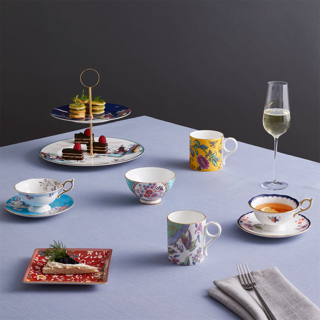 Set de té Midnight Crane Wonderlust sobre mesa elegante con otras porcelanas