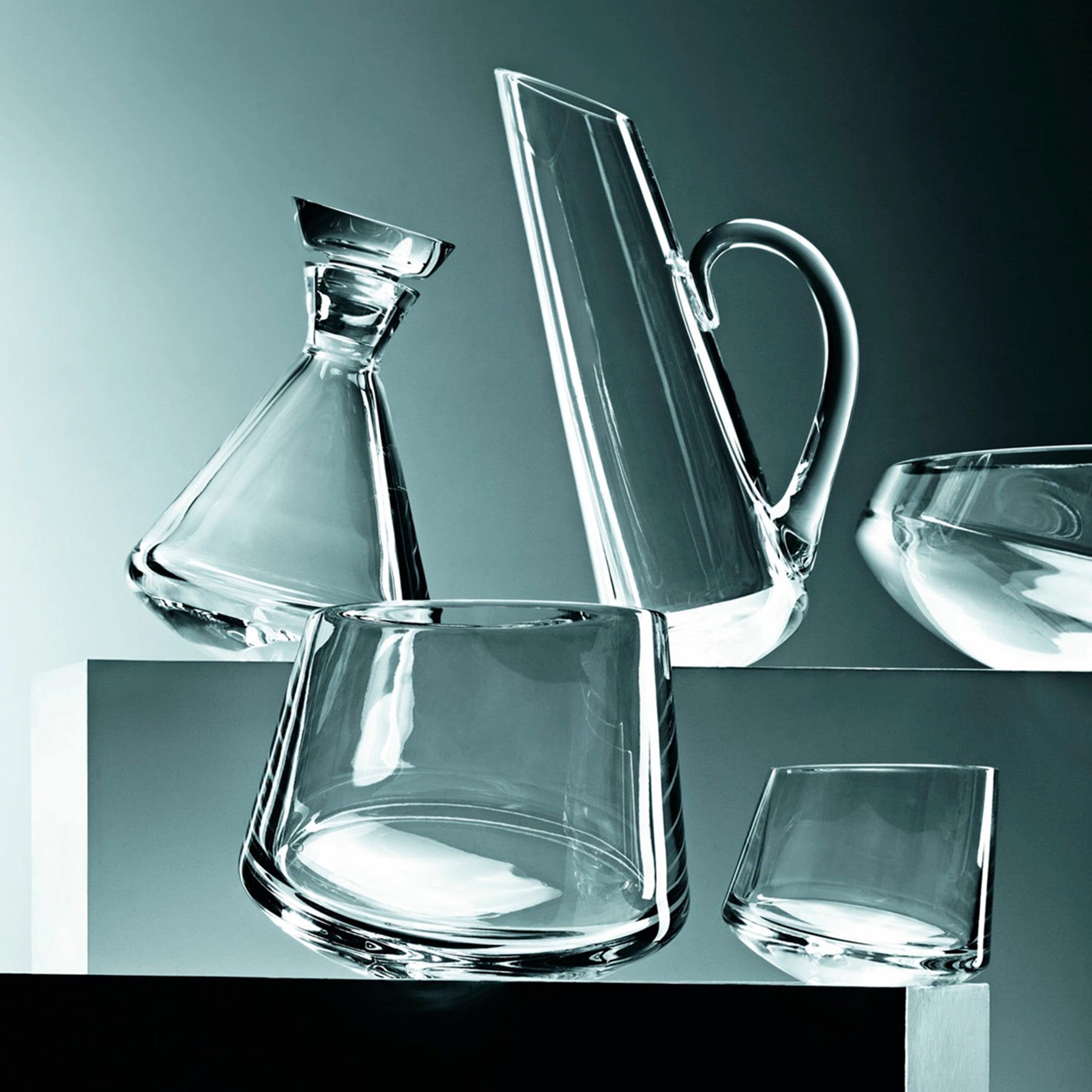 Jarra Zanzibar de Vista Alegre en una mesa con mas piezas de la colección, ilustrando su inclinación y su diseño contemporáneo.