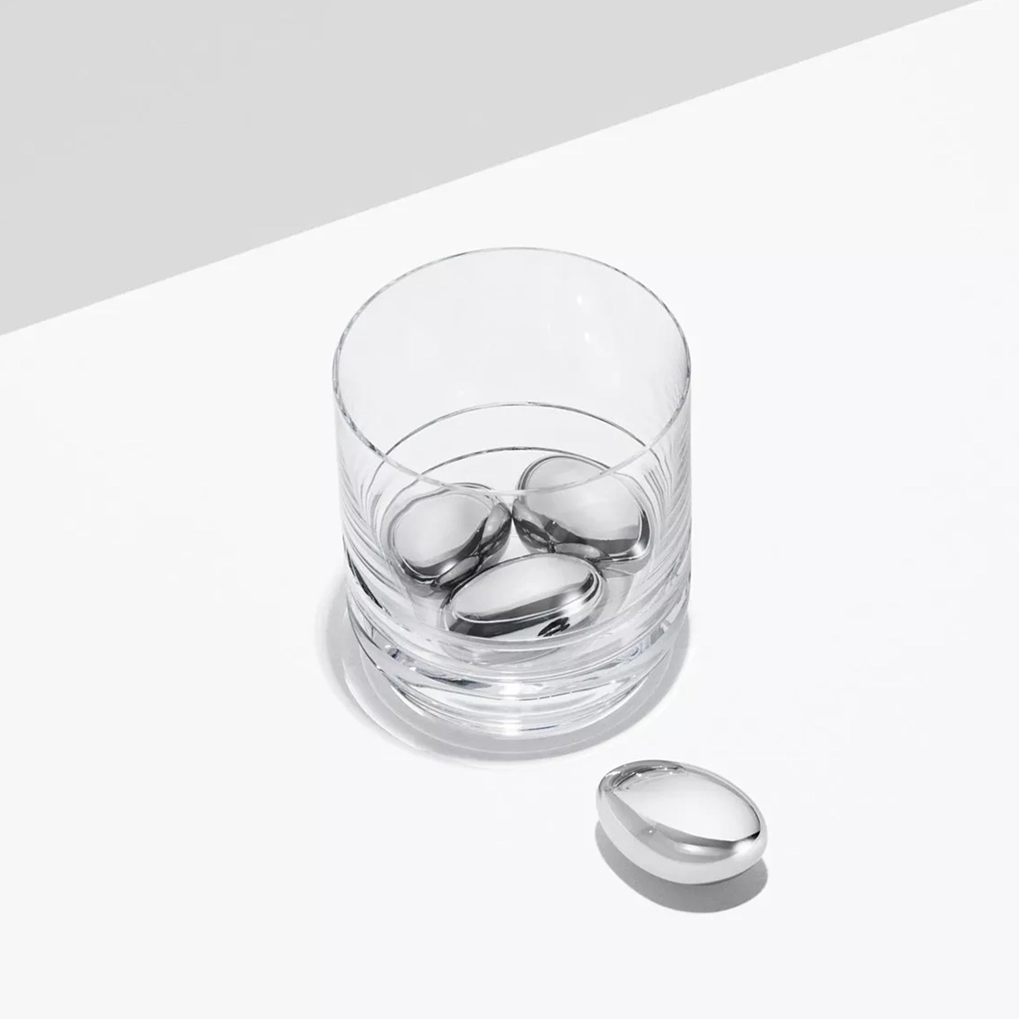 Cubos de hielo Sky, resaltando el brillo del acero inoxidable pulido a espejo, listos para enfriar un trago de whisky.