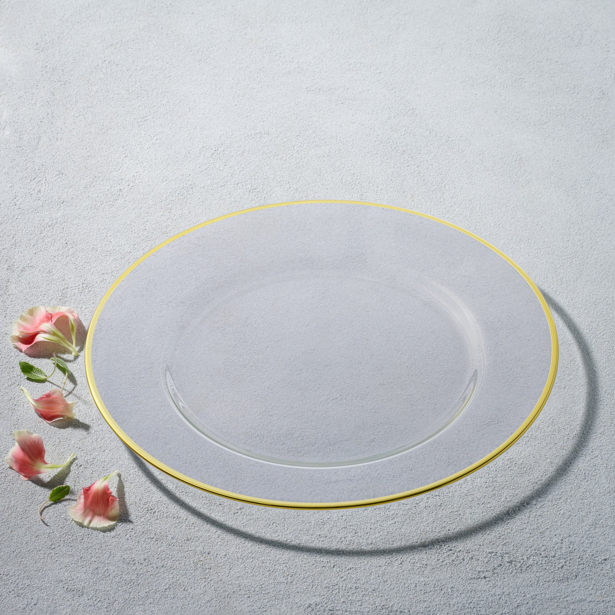 Plato Base Vikko Gold de Kadra en una mesa elegantemente decorada.
