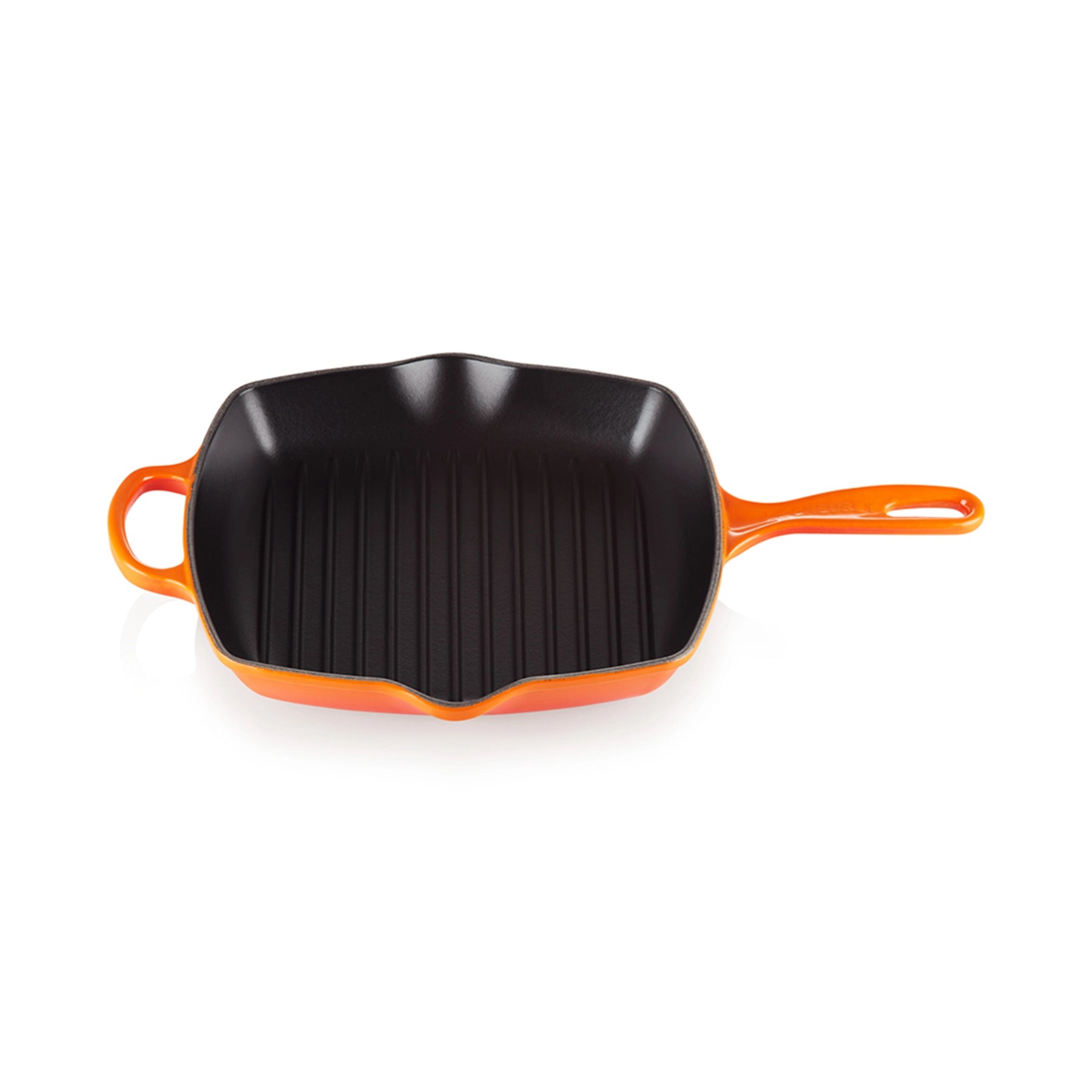 Skillet Grill Cuadrada de Le Creuset, mostrando su superficie interior estriada de hierro fundido para asar alimentos.