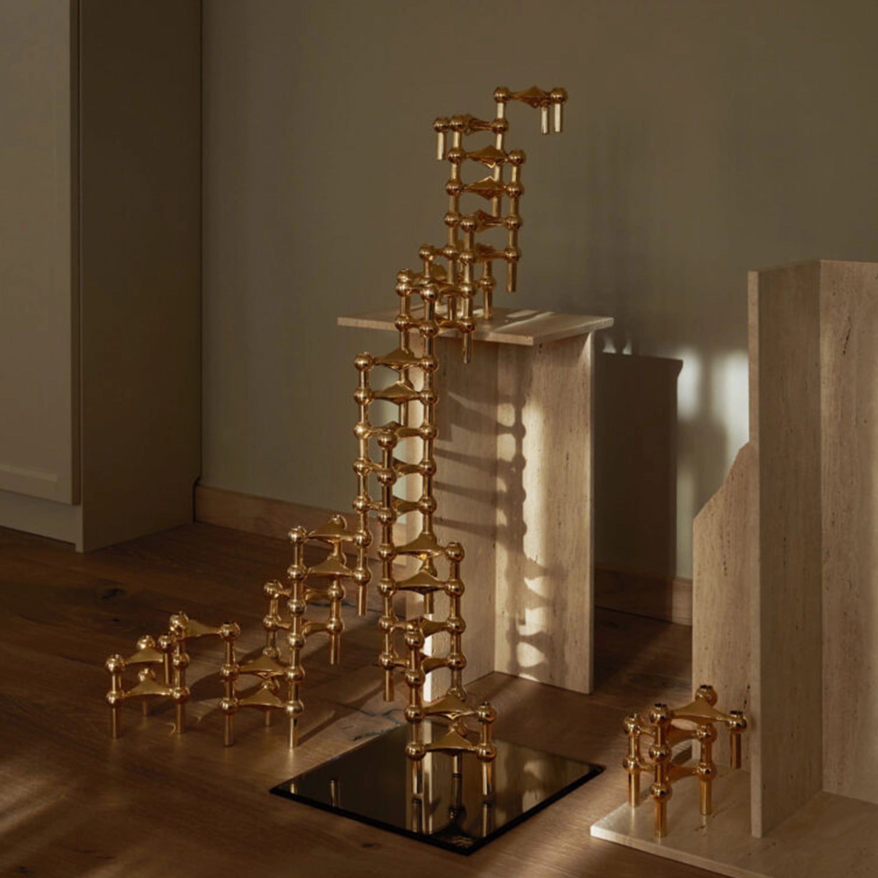 Candelabro dorado STOFF Nagel combinado con otras piezas de la colección.