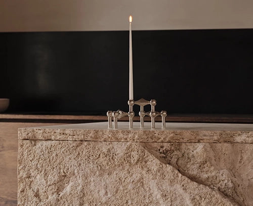 Portavelas Stoff Nagel con velas encendidas, creando un ambiente acogedor y cálido sobre una mesa.