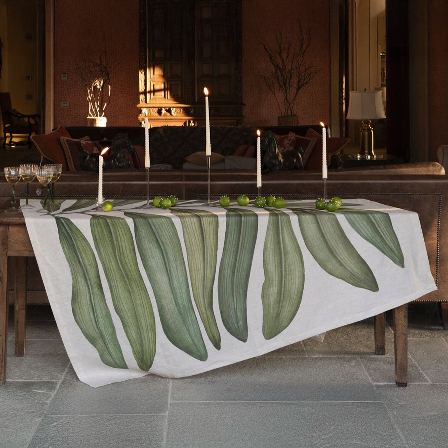 Mantel Tamarindo de Tessitura Toscana Telerie desplegado en una mesa, mostrando el diseño exótico y vibrante de la tela de lino.