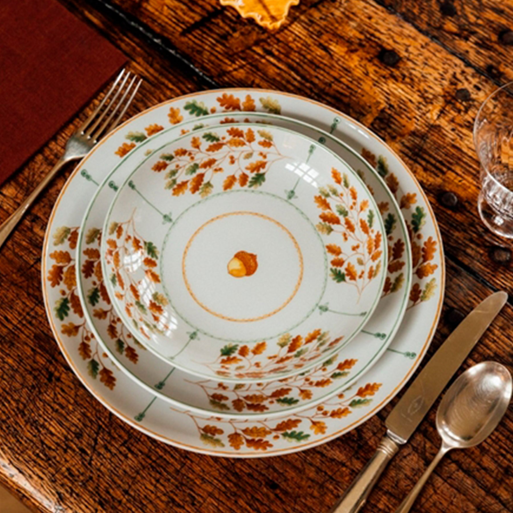 Platos de la colección Gudrun de Vista Alegre listos para servir sobre una mesa de madera artesanal.